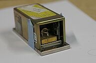 Close-up image of a laser diode equipped with two tiny optical prisms attached.