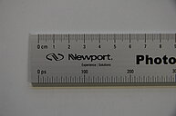 Photo of a specialized measuring device, resembling a ruler, designed to measure the speed of light. The device includes a precisely marked scale used to determine the distance (in centimeters) light travels in a given time (in pico seconds)