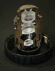 Photo of a microscope objective cut in half. The arrangement of the various lenses inside the objective is visible.