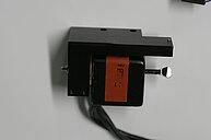 Photo of a scanning mirror of a lascer scanning microscope is shown. A tiny mirror on much bigger holder is visible.